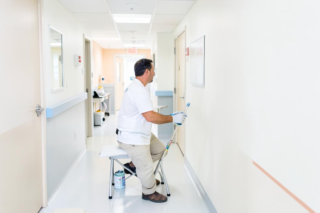 Painter using low-odor paint in a medical clinic corridor in Georgia